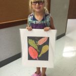 A Little Girl Holding Artwork of Leaves