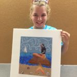 A Little Girl Holding an Artwork of a Mermaid